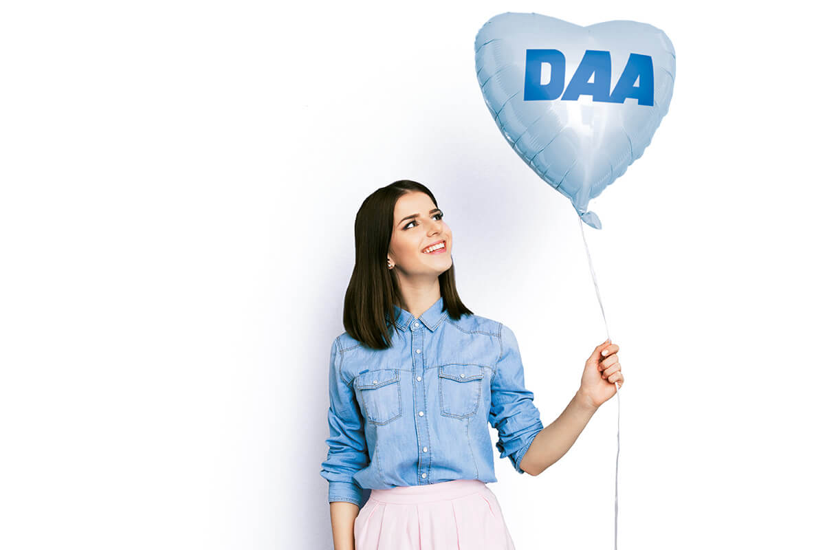 Eine Frau mit einem Herzluftballon, auf dem das DAA-Logo zu sehen ist