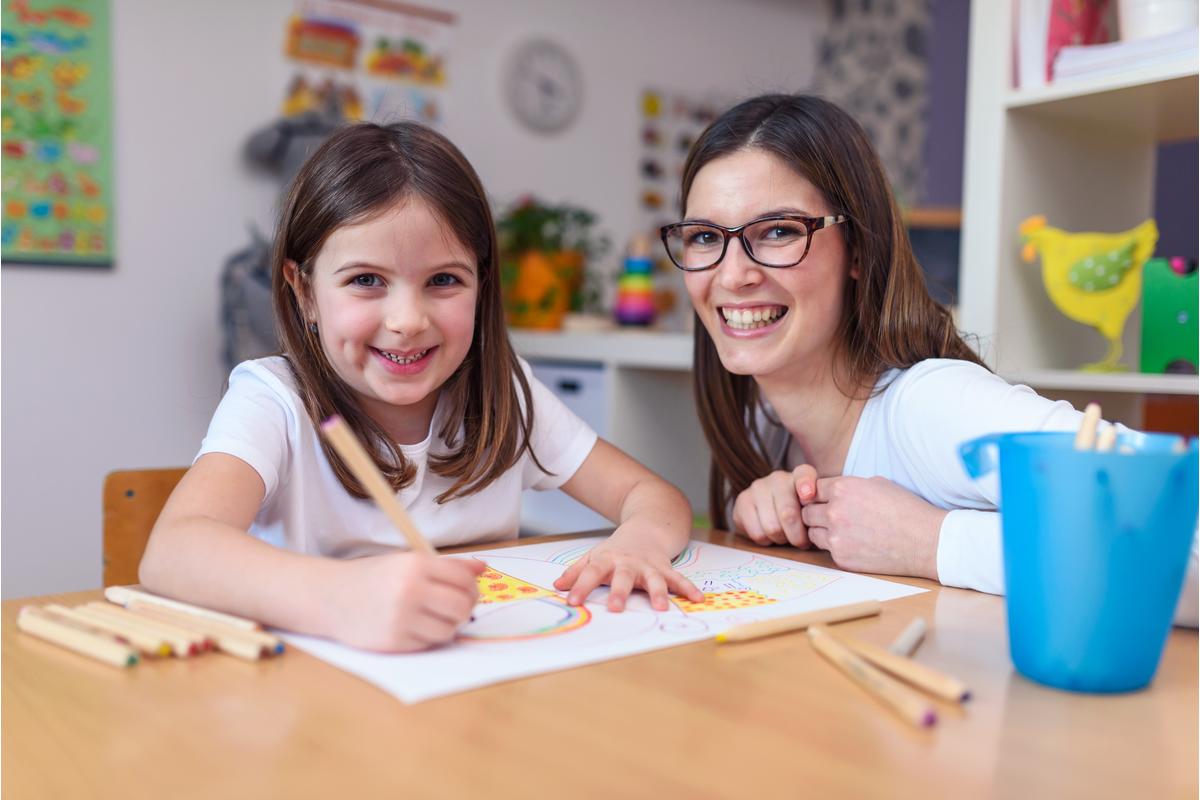 Eine Erzieherin und ein Mädchen Malen im Kindergarten ein Bild