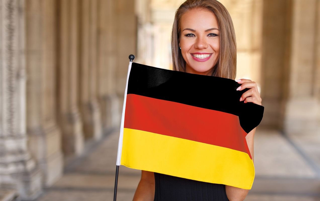 eine junge Frau hält eine Deutschlandflagge in der Hand