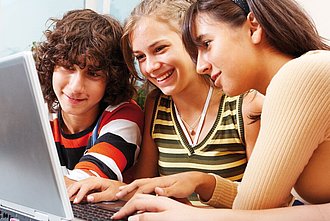 Drei Schüler*innen am Laptop